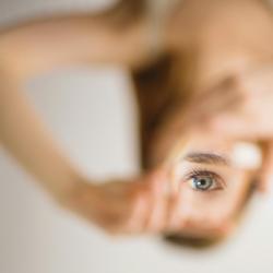 A distorted, inverted image of a woman looking through a magnifying glass.